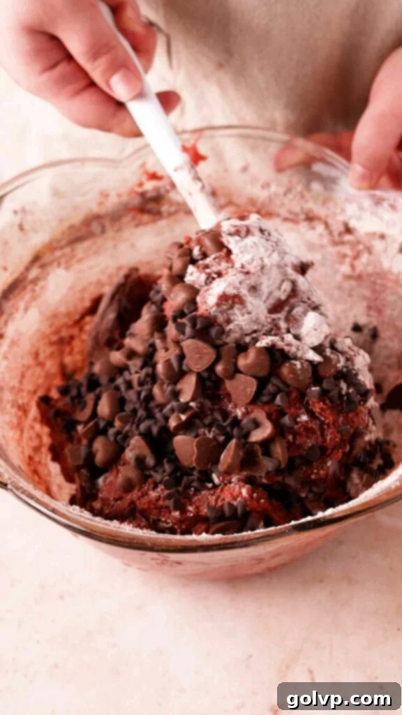Mixing red velvet brownie batter with a spatula, ensuring all ingredients are just combined.