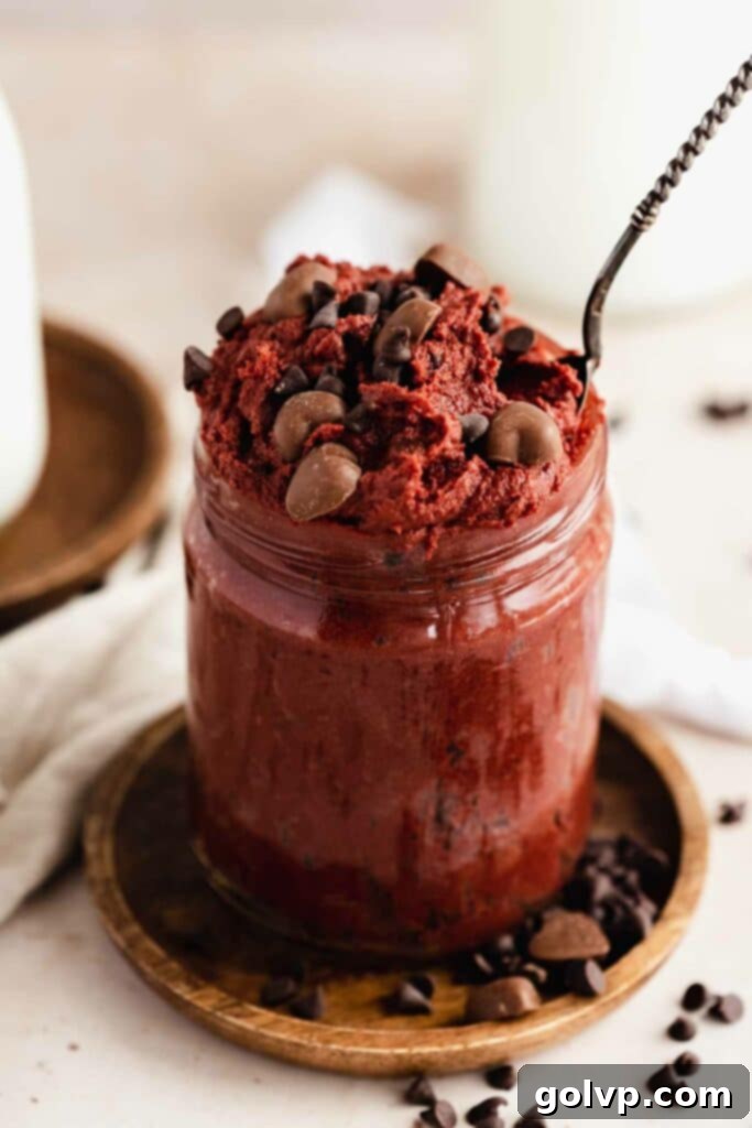 Red velvet cookie dough in jar with spoon