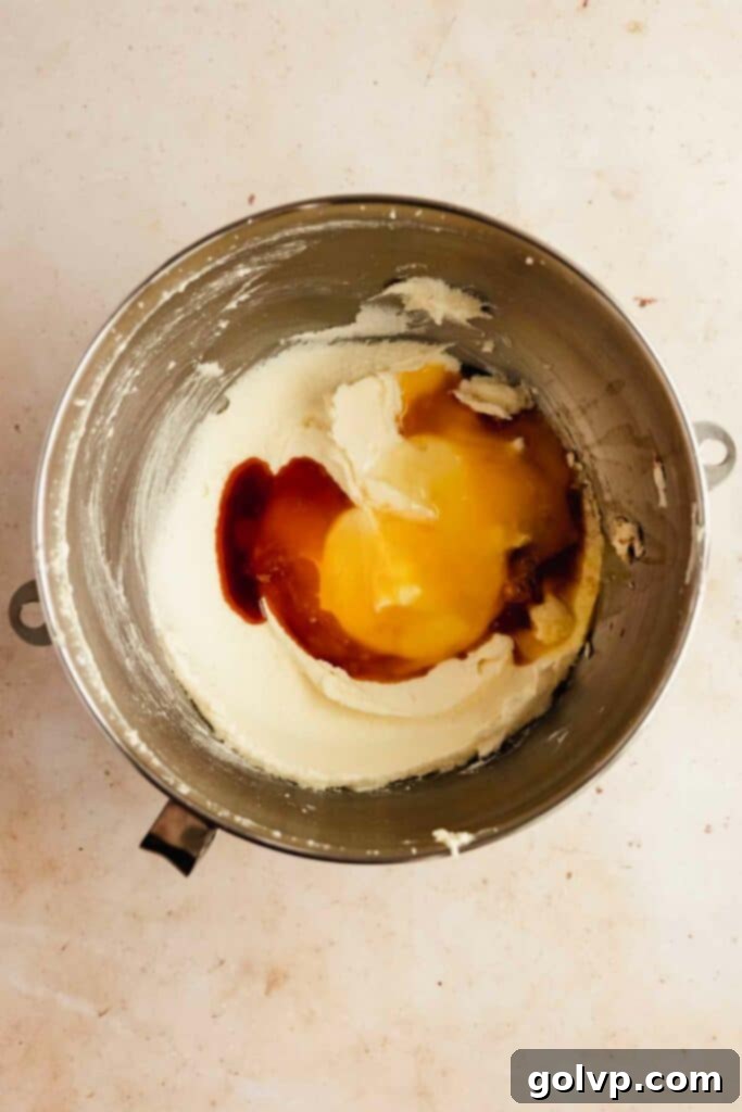 Adding eggs into cookie dough