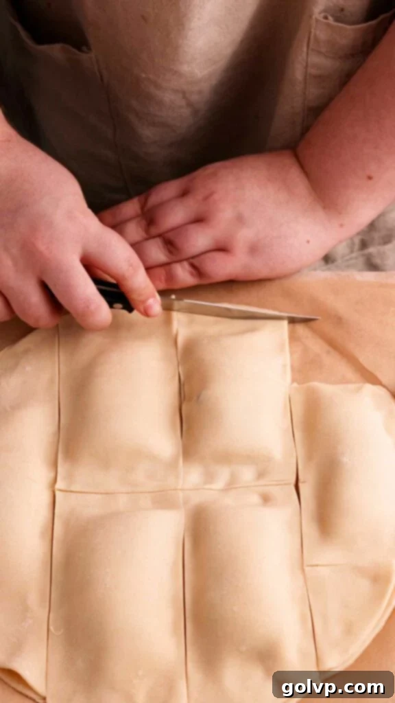 Cutting and trimming the assembled pop tarts into neat rectangular shapes before baking.