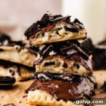 Stack of homemade Oreo Pop Tarts with flaky crusts, creamy filling, and chocolate glaze topped with crushed Oreos.