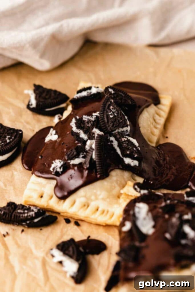 Close-up of a homemade Oreo Pop Tart covered in thick chocolate glaze and sprinkled with crushed Oreo pieces.