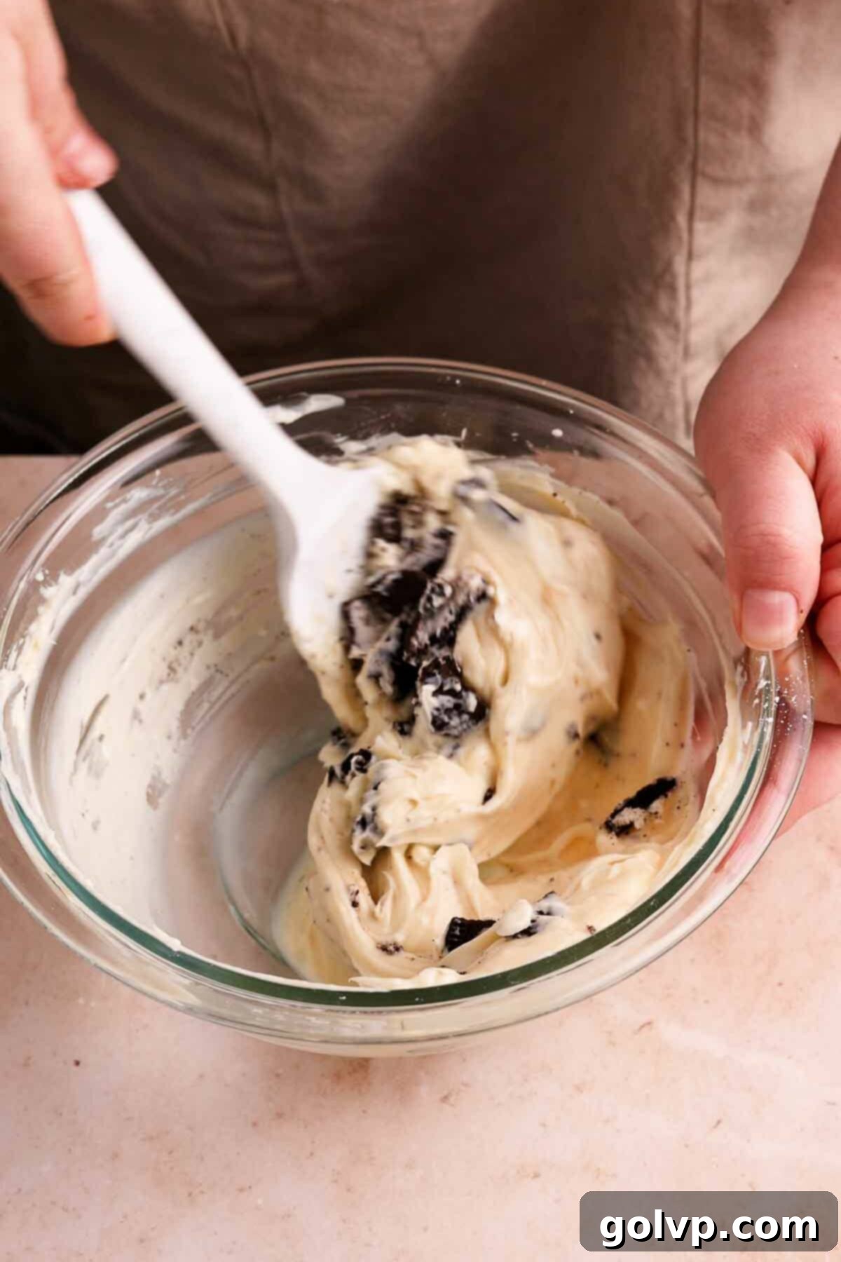 Mixing softened cream cheese, powdered sugar, and vanilla extract for the creamy Oreo filling.