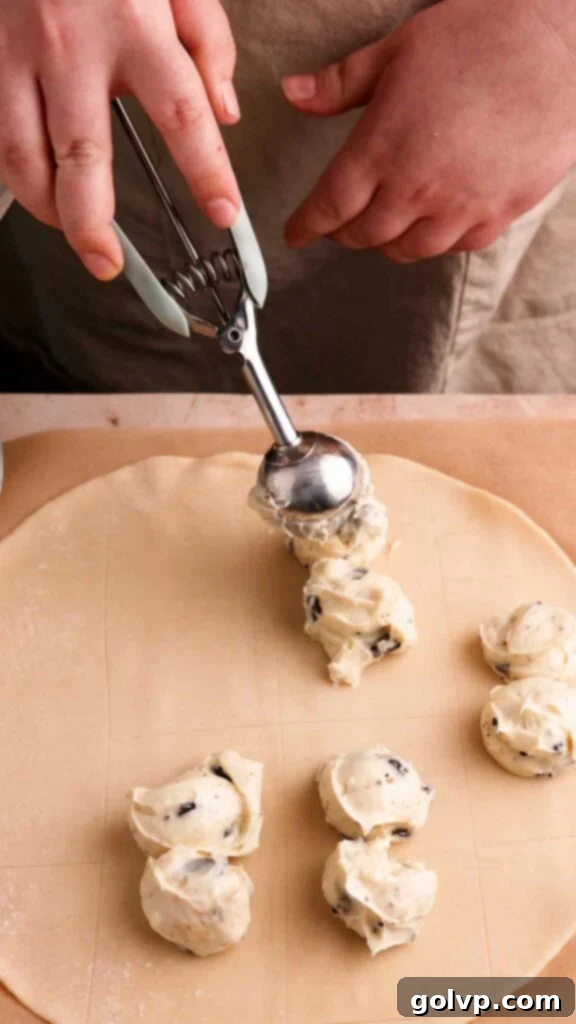 Carefully adding creamy Oreo filling to the center of marked rectangles on the pie crust.