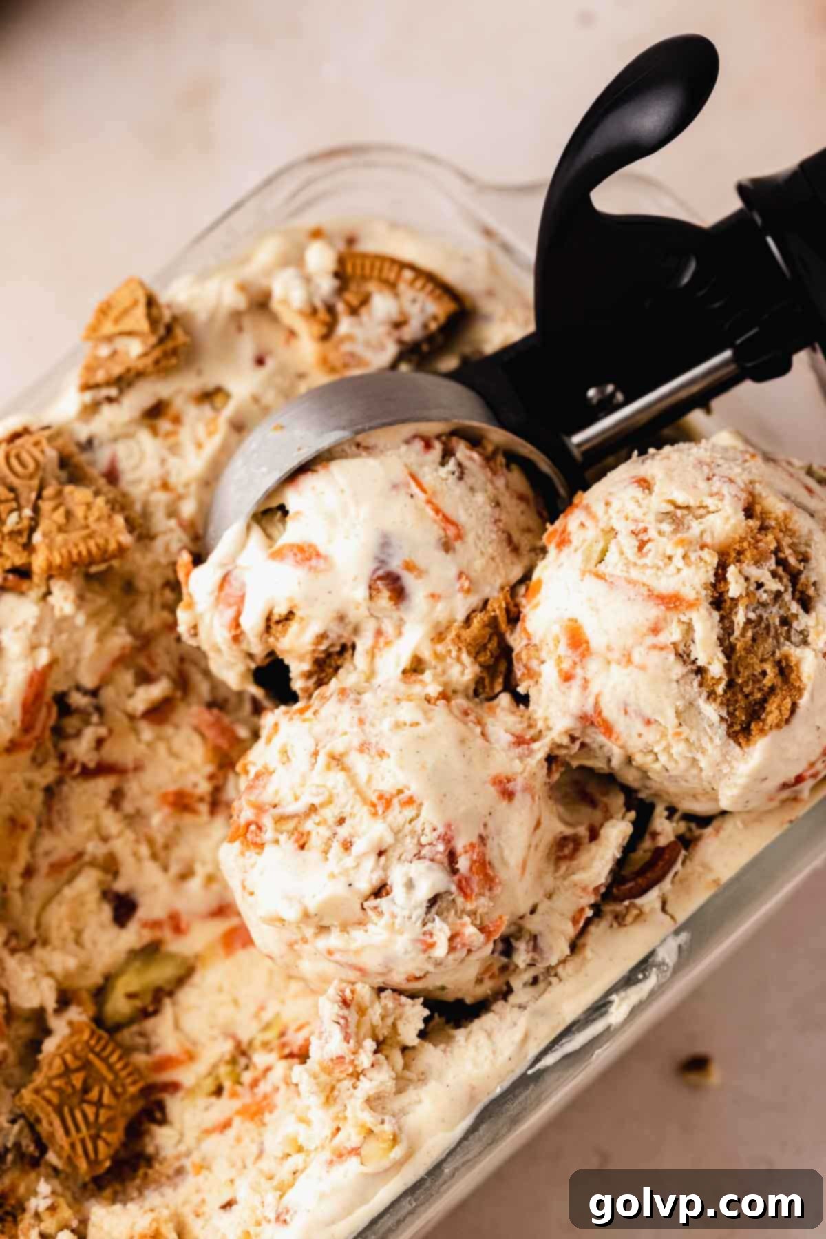 Spiced Carrot Cake Swirl 10 scooping creamy carrot cake ice cream from a loaf pan