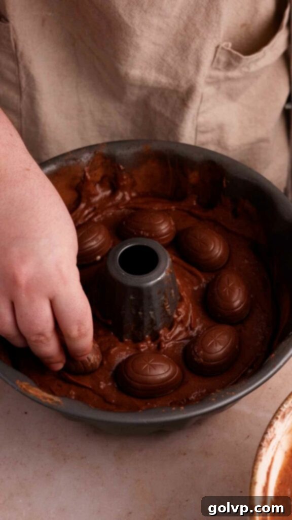 Placing a layer of Cadbury creme eggs into the middle of a chocolate bundt cake batter.