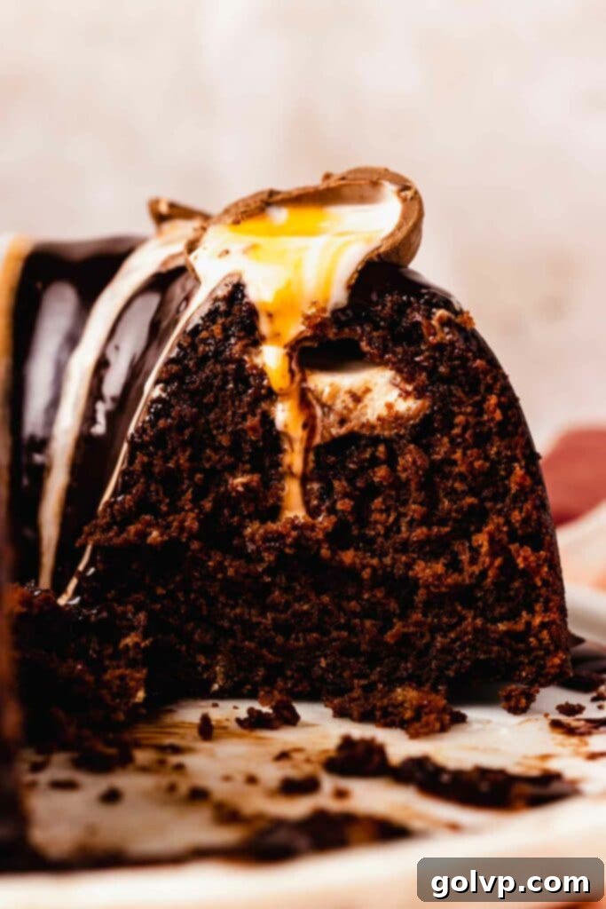 Close-up of a melted Cadbury creme egg on top of a chocolate bundt cake, showcasing the gooey filling.