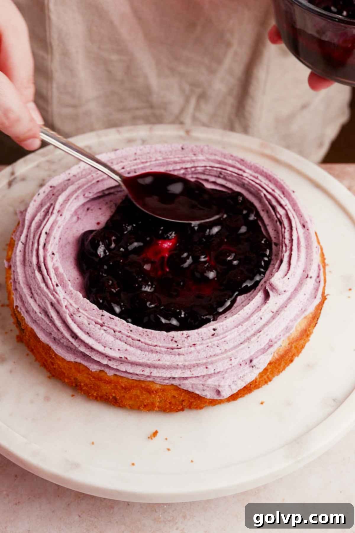 adding blueberry filling into middle of blueberry cake