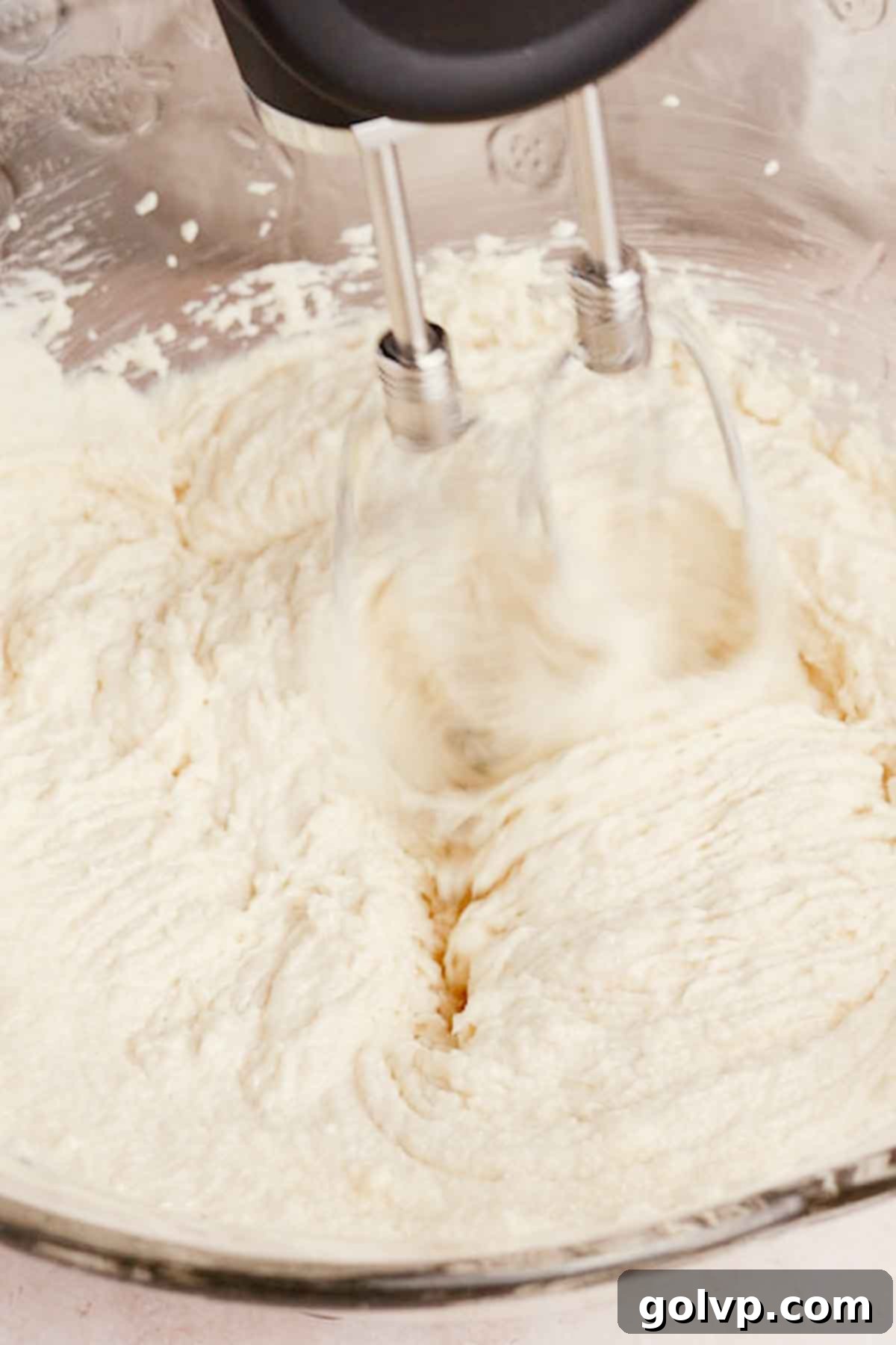 whipping sugar and butter and oil until very thick with an electric mixer in glass bowl