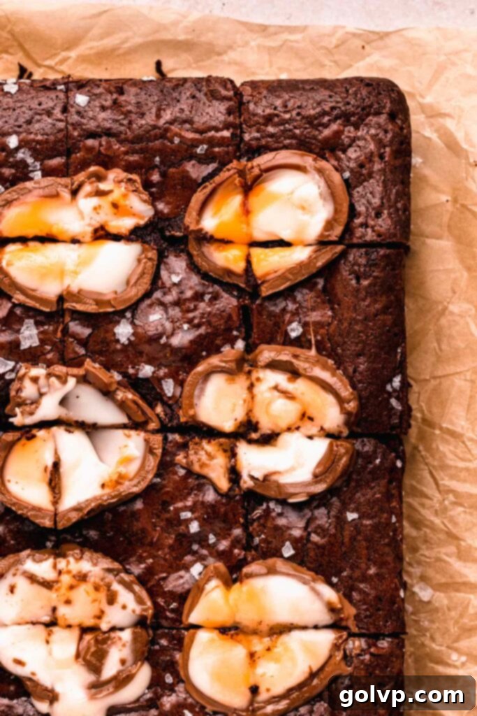 A tray of freshly baked Cadbury Creme Egg Brownies with their signature crinkly tops, ready to be sliced.