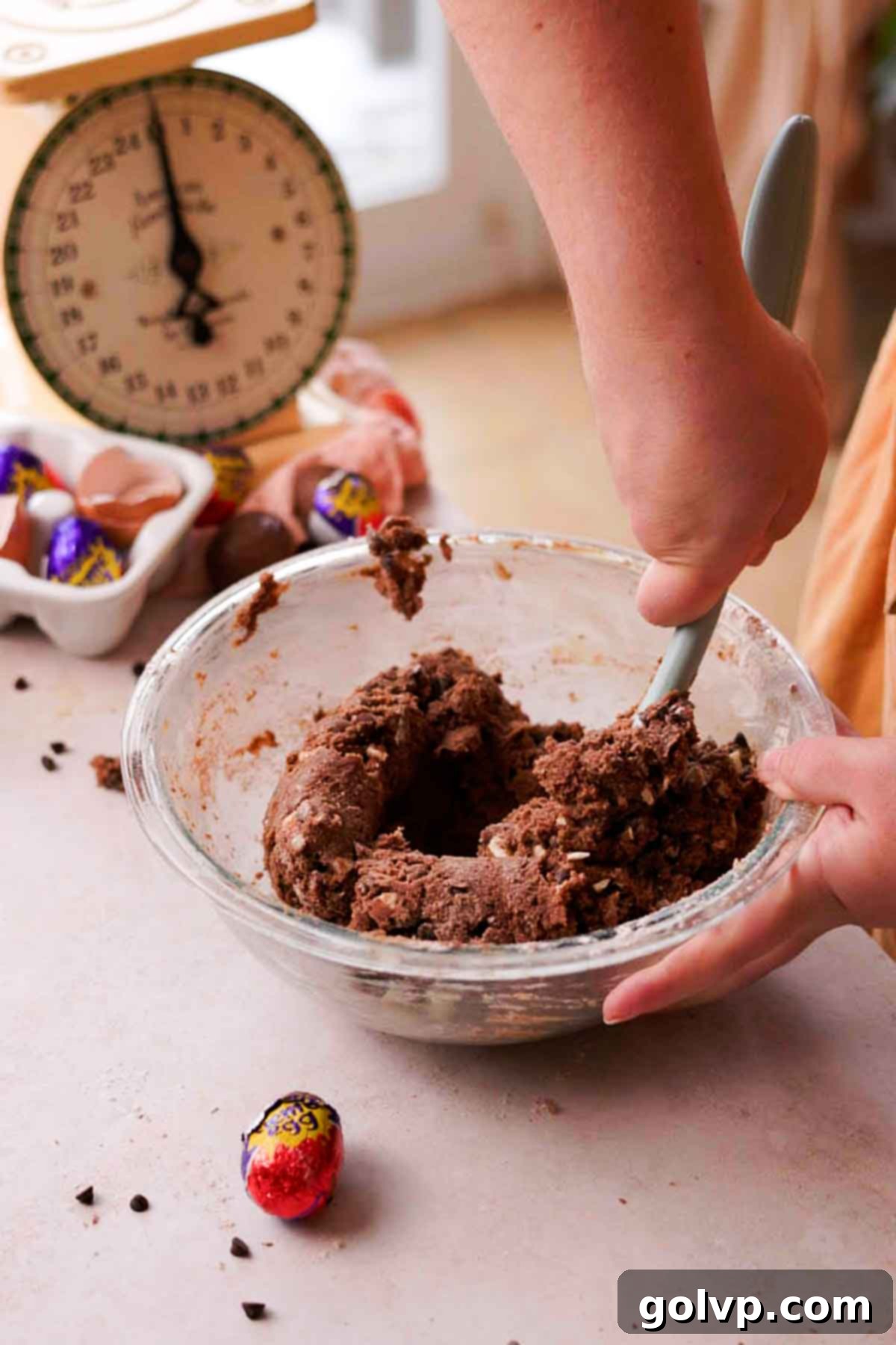 Stirring chocolate chips into creme egg cookie dough