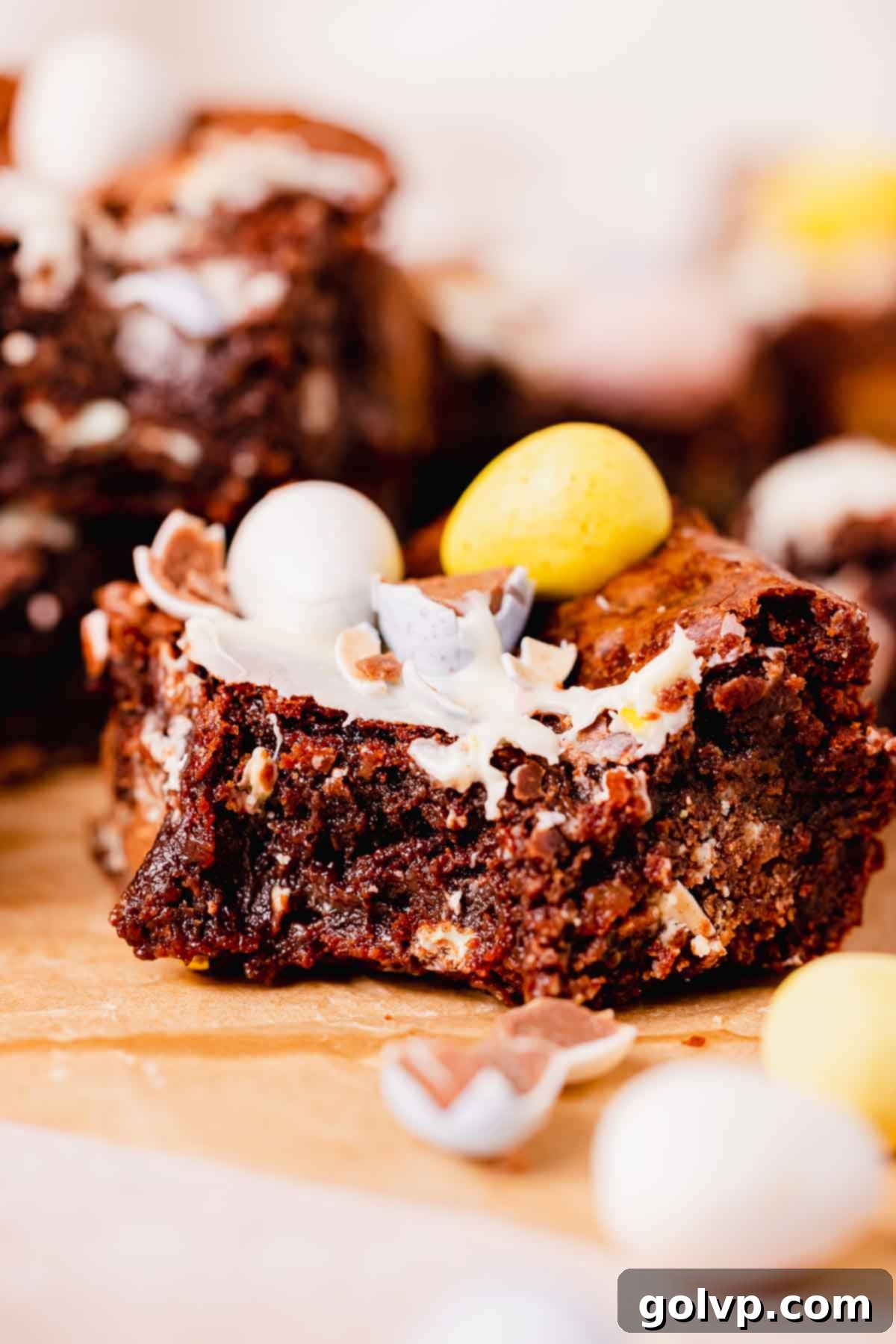bitten mini egg brownie square with mini eggs on top, showing its gooey center