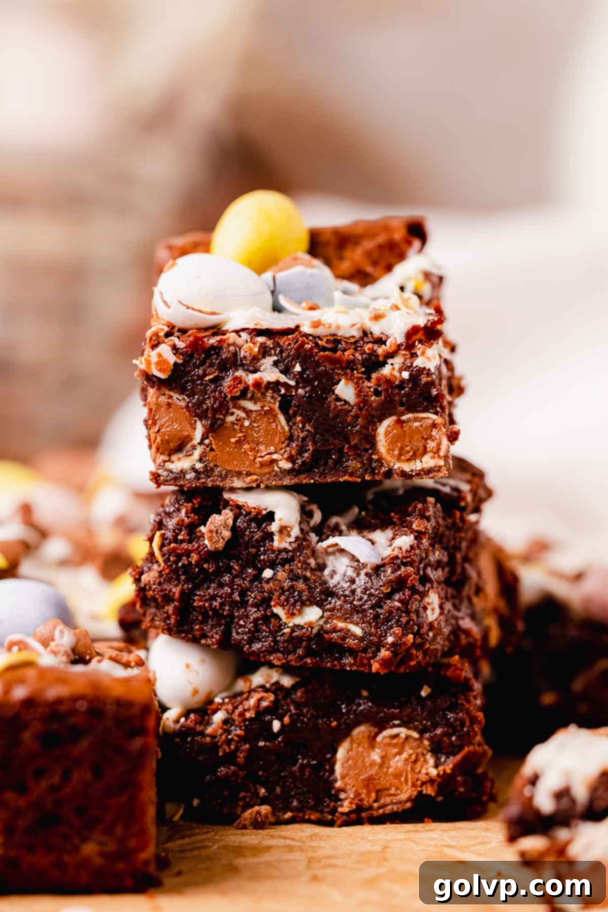 stack of three fudgy mini egg brownie squares, showing the interior and scattered mini eggs