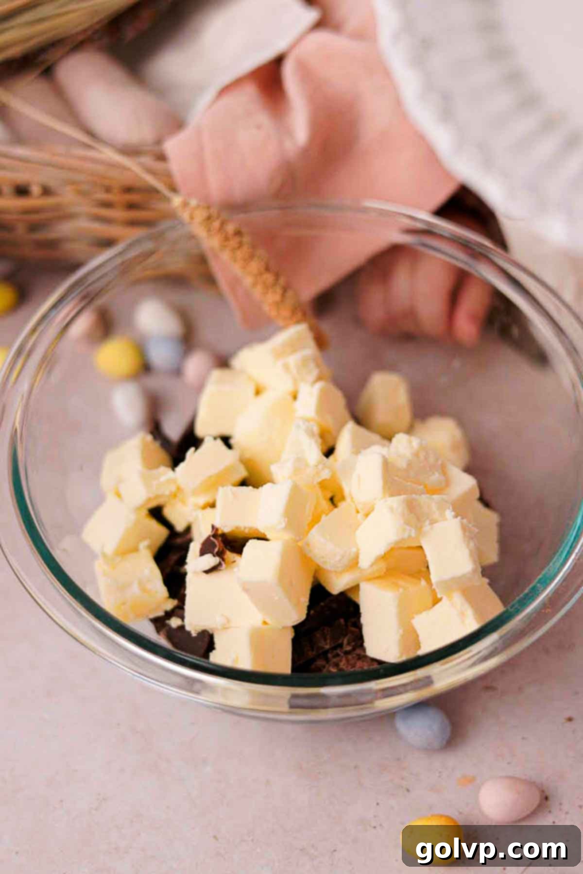 combining cubed butter and chocolate in glass bowl over a saucepan with simmering water