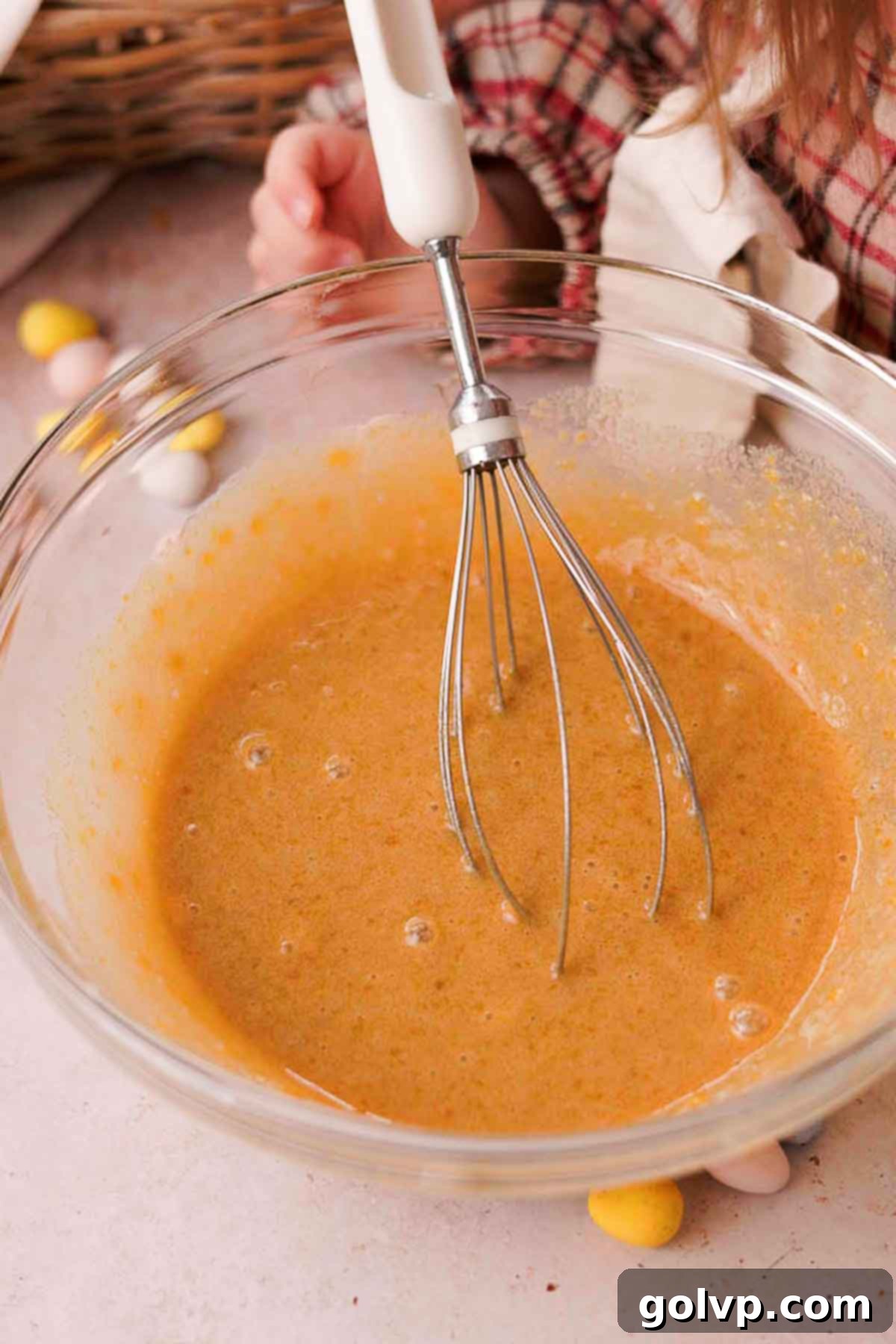 whisking eggs and sugar in glass bowl with wire whisk until light and frothy