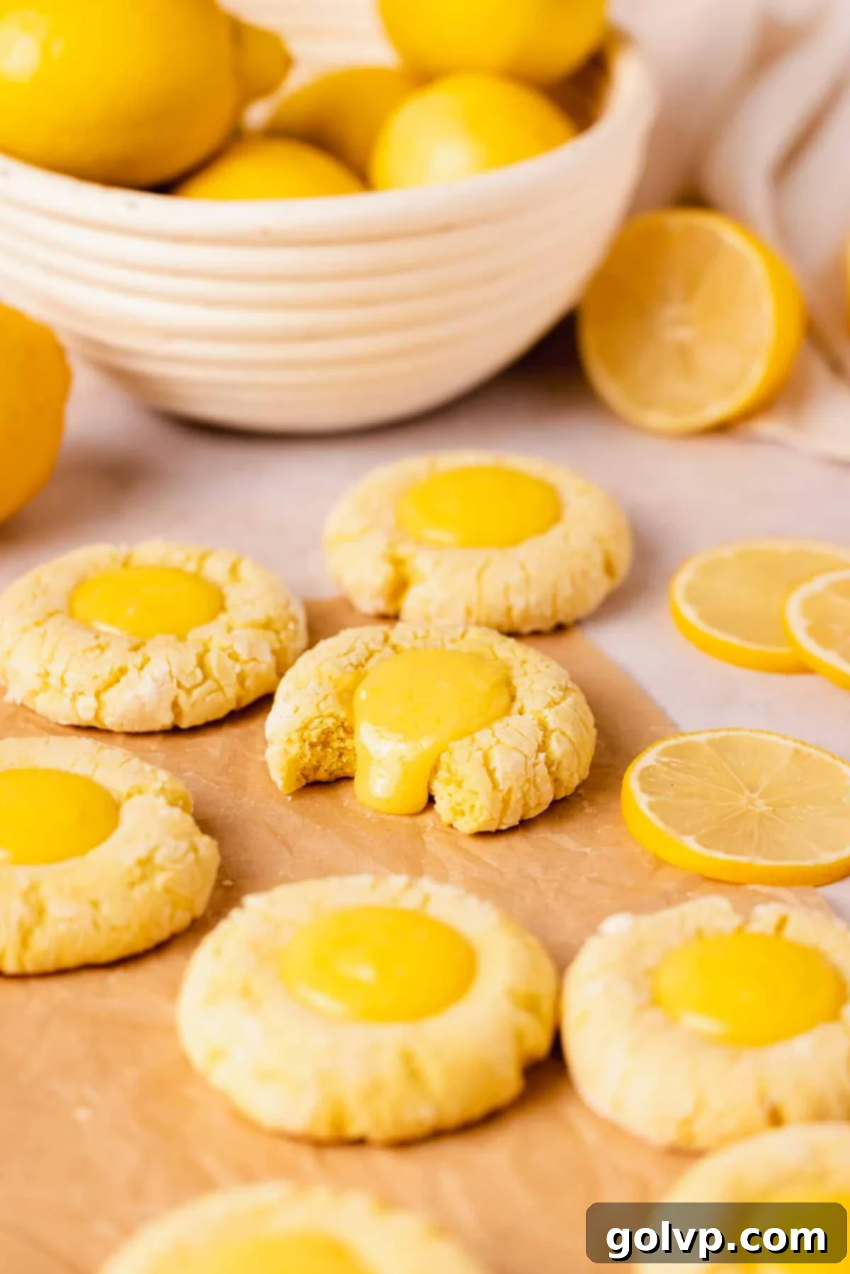 Crinkle cookies with bright yellow lemon curd filling and one cookie expertly bitten to reveal the gooey center