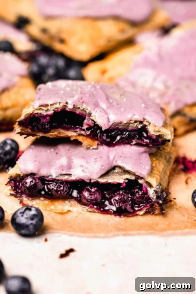 Filled blueberry pop tart cut in half, showcasing the gooey filling and flaky crust