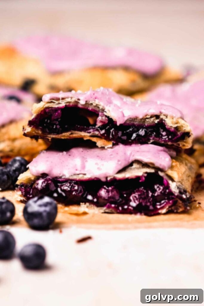 Halved blueberry pop tarts stacked on top of eachother, showcasing the layers