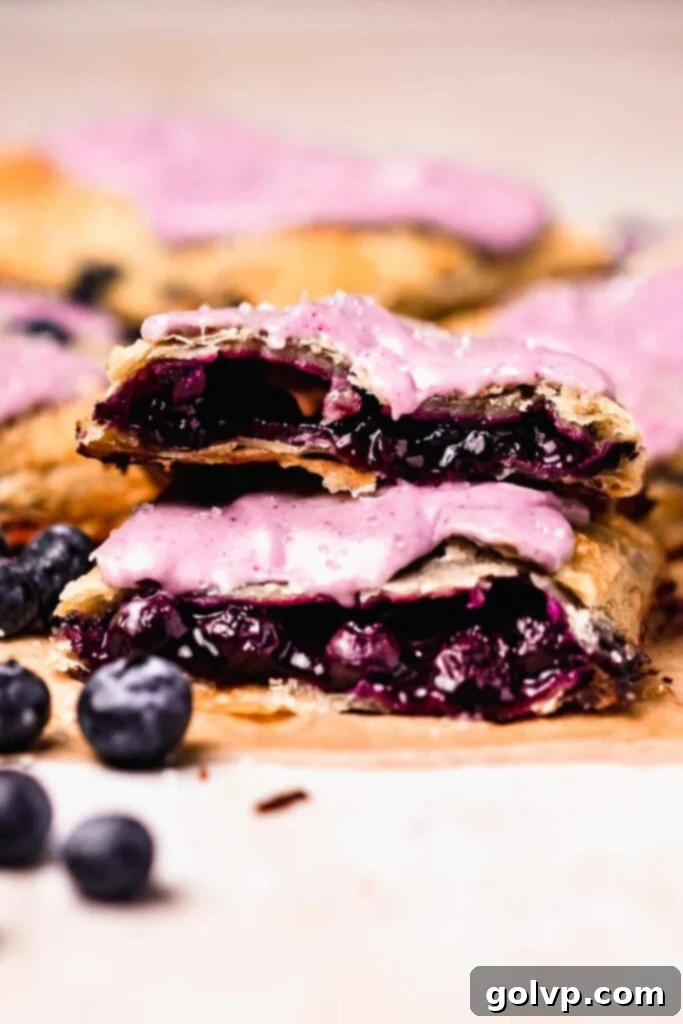 Halved blueberry pop tarts stacked on top of each other, showing the filling and crust layers