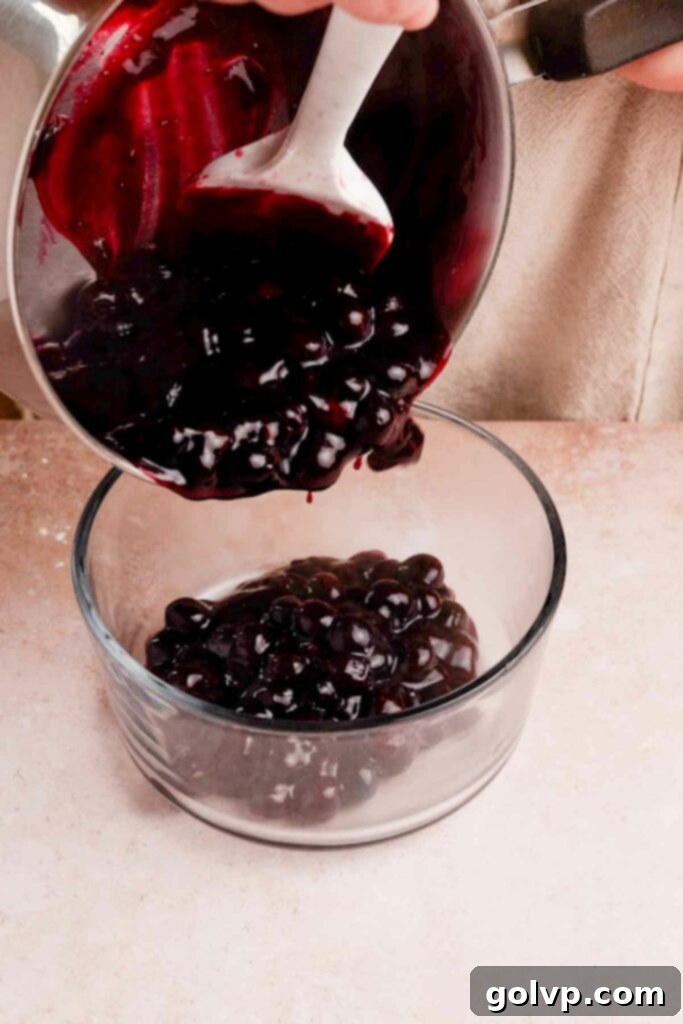 Pouring homemade blueberry pop tart filling into a glass container to cool