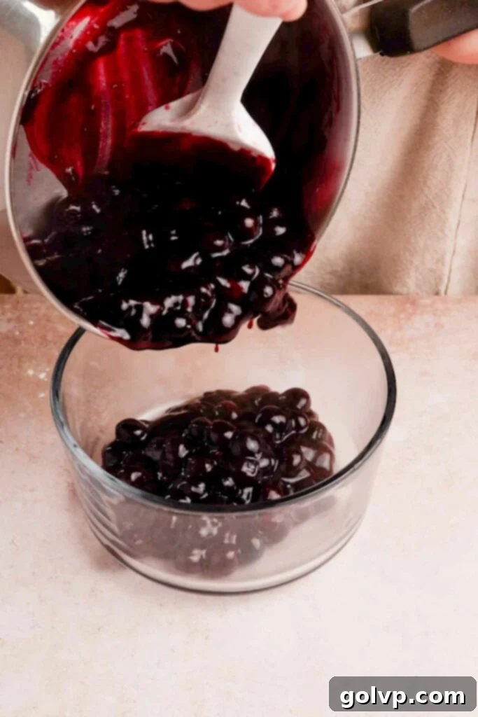 Pouring homemade blueberry pop tart filling into a glass container to cool