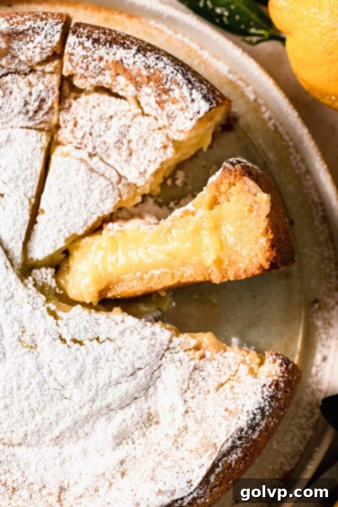A slice of lemon butter cake with a gooey center on a white plate