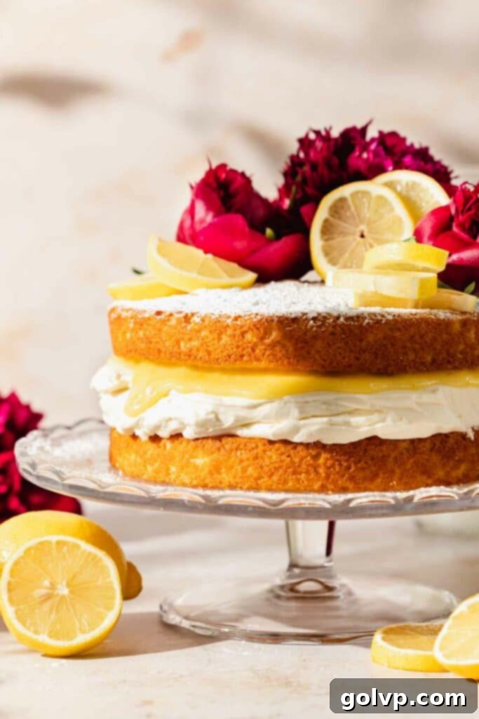 Zesty Lemon Victoria Sponge 2 Victoria sponge topped with powdered sugar, lemon slices, and peonies