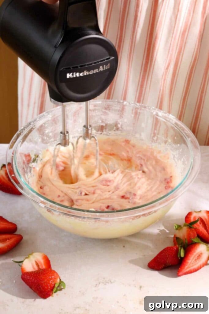 Beating strawberry filling ingredients together until smooth and creamy.