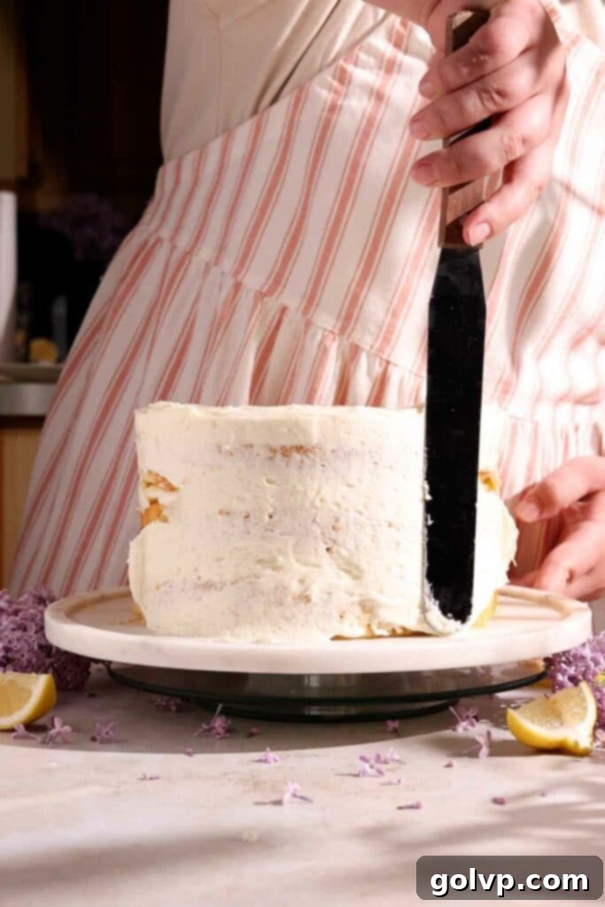 Applying a crumb coat of frosting to a stacked cake