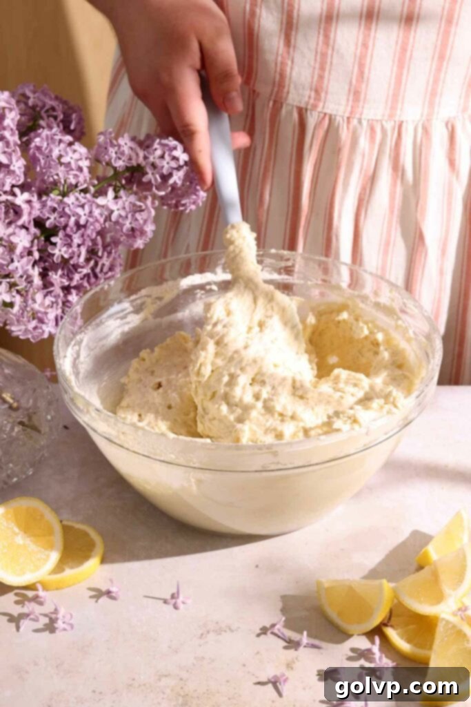 Prepared cake batter with small specks of lilac petals, ready for baking