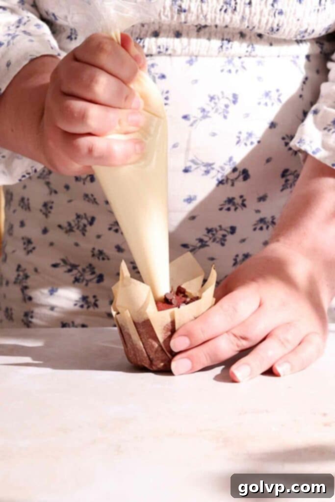 filling muffins with cream cheese filling using a piping bag