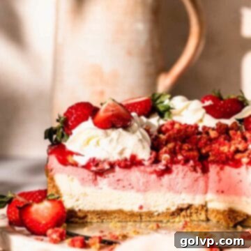 sliced strawberry cheesecake topped with strawberry crunch and whipped cream