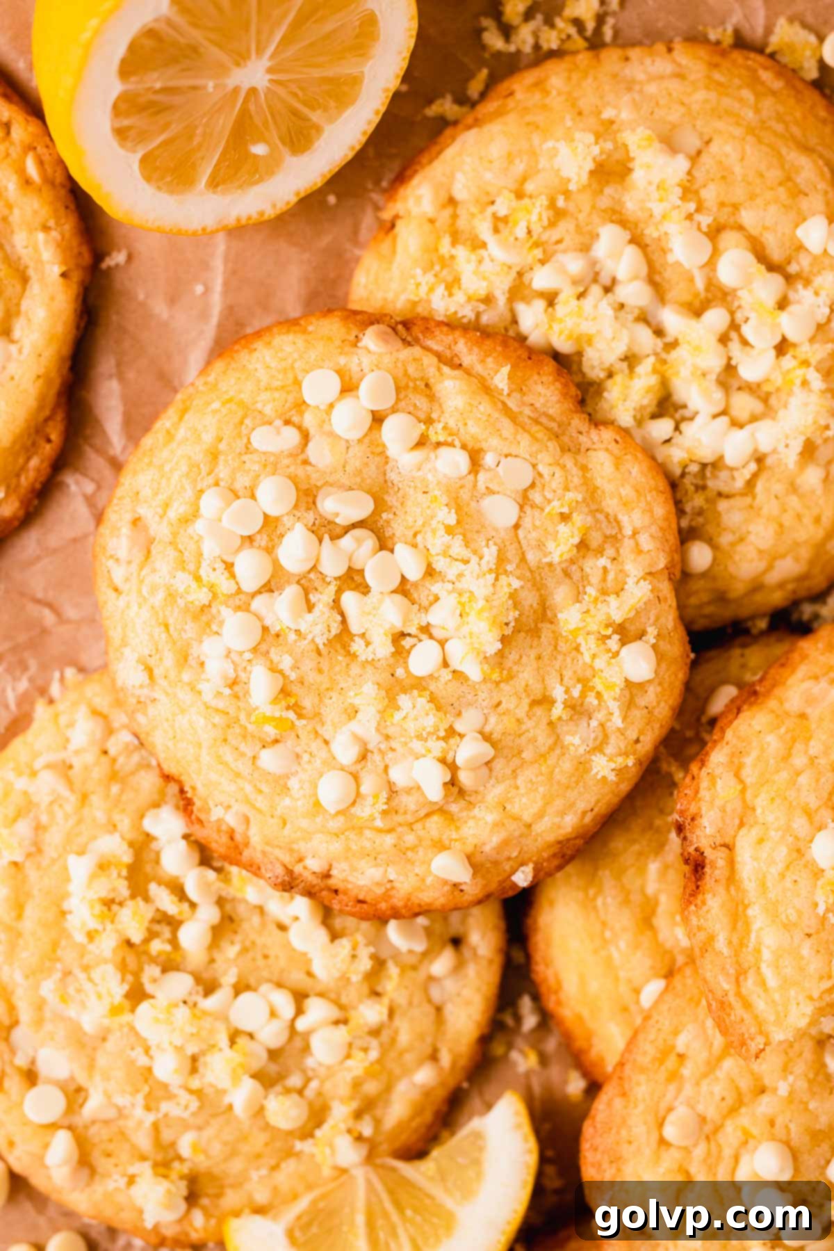 A close-up of the top of a lemon white chocolate chip cookie, showing the golden texture and visible chips.