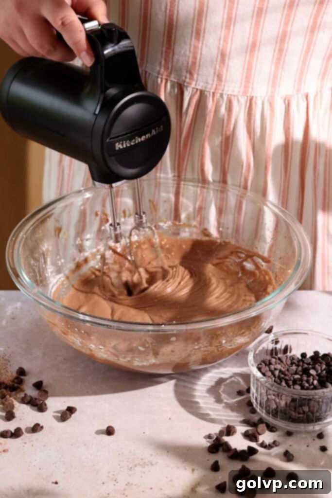 Beating the cream cheese, sugar, egg, and cocoa powder together for the gooey filling.