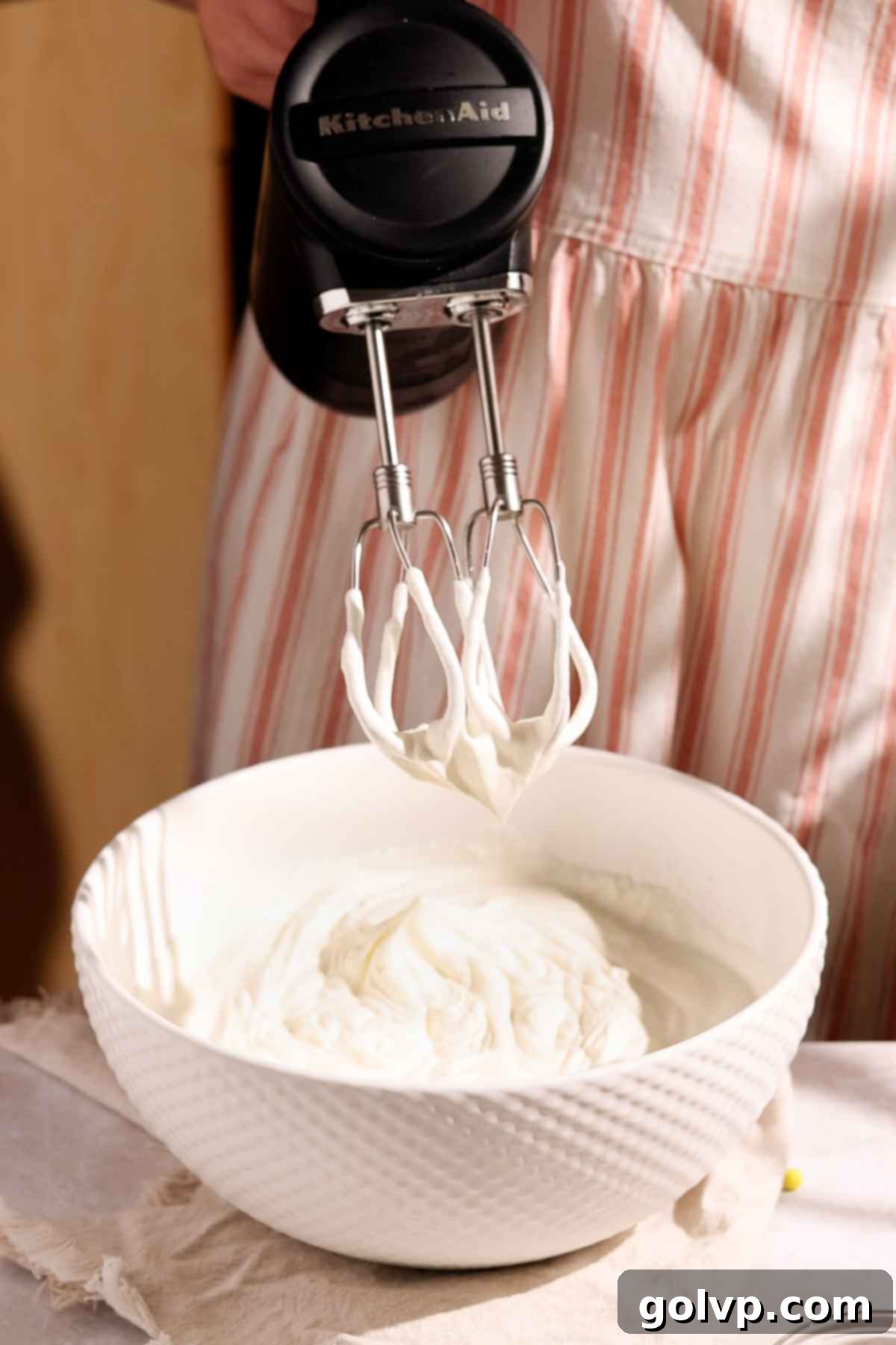 Joyful Confetti Cream 4 Close-up of heavy cream being whipped in a chilled bowl with an electric mixer