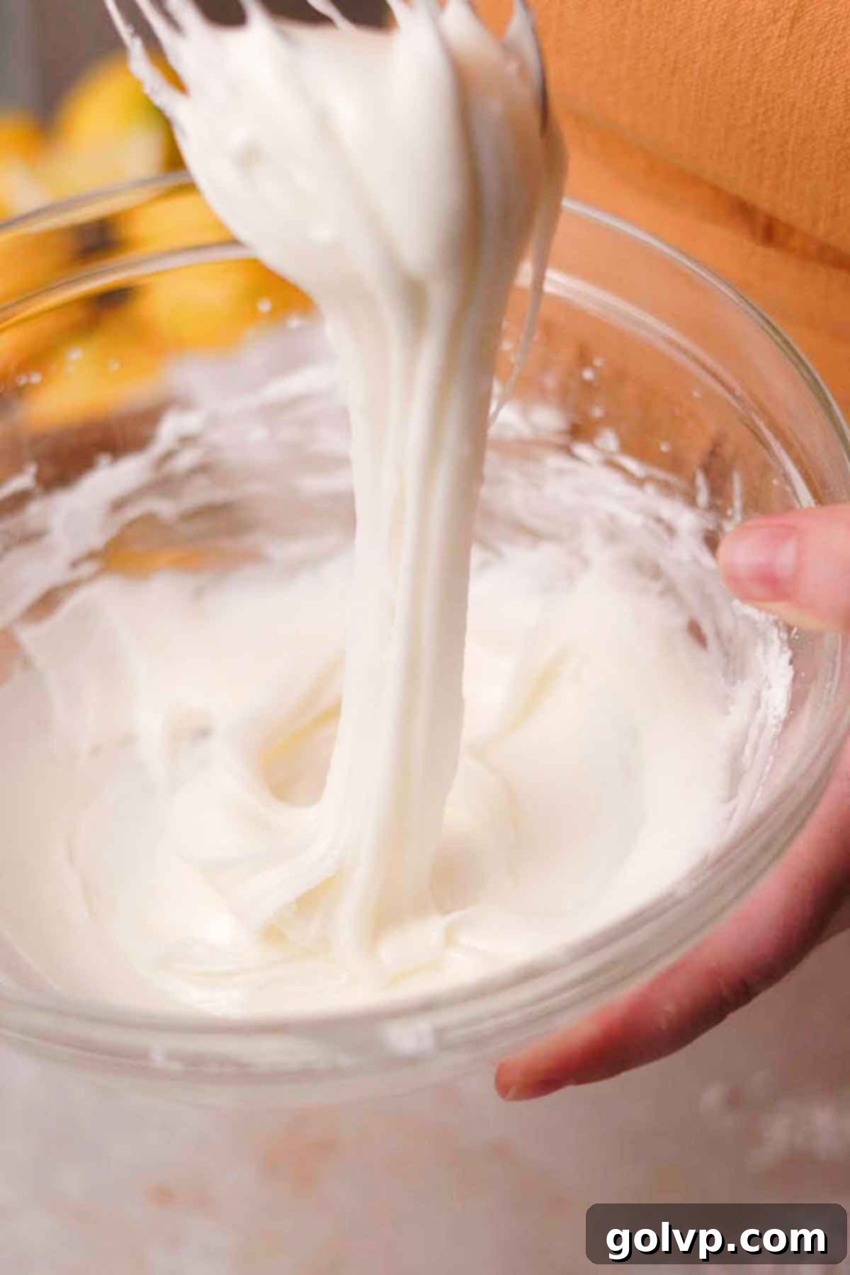 whisking lemon juice and powdered sugar in glass bowl to a thick consistency