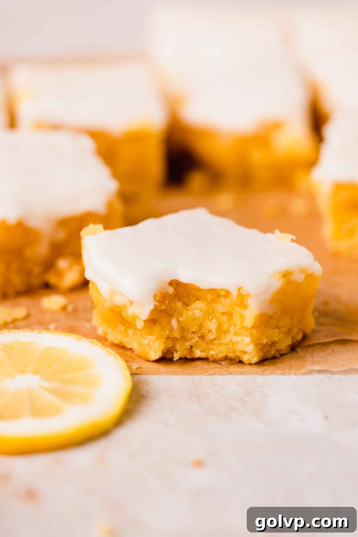 bitten lemon brownie square topped with white lemon glaze