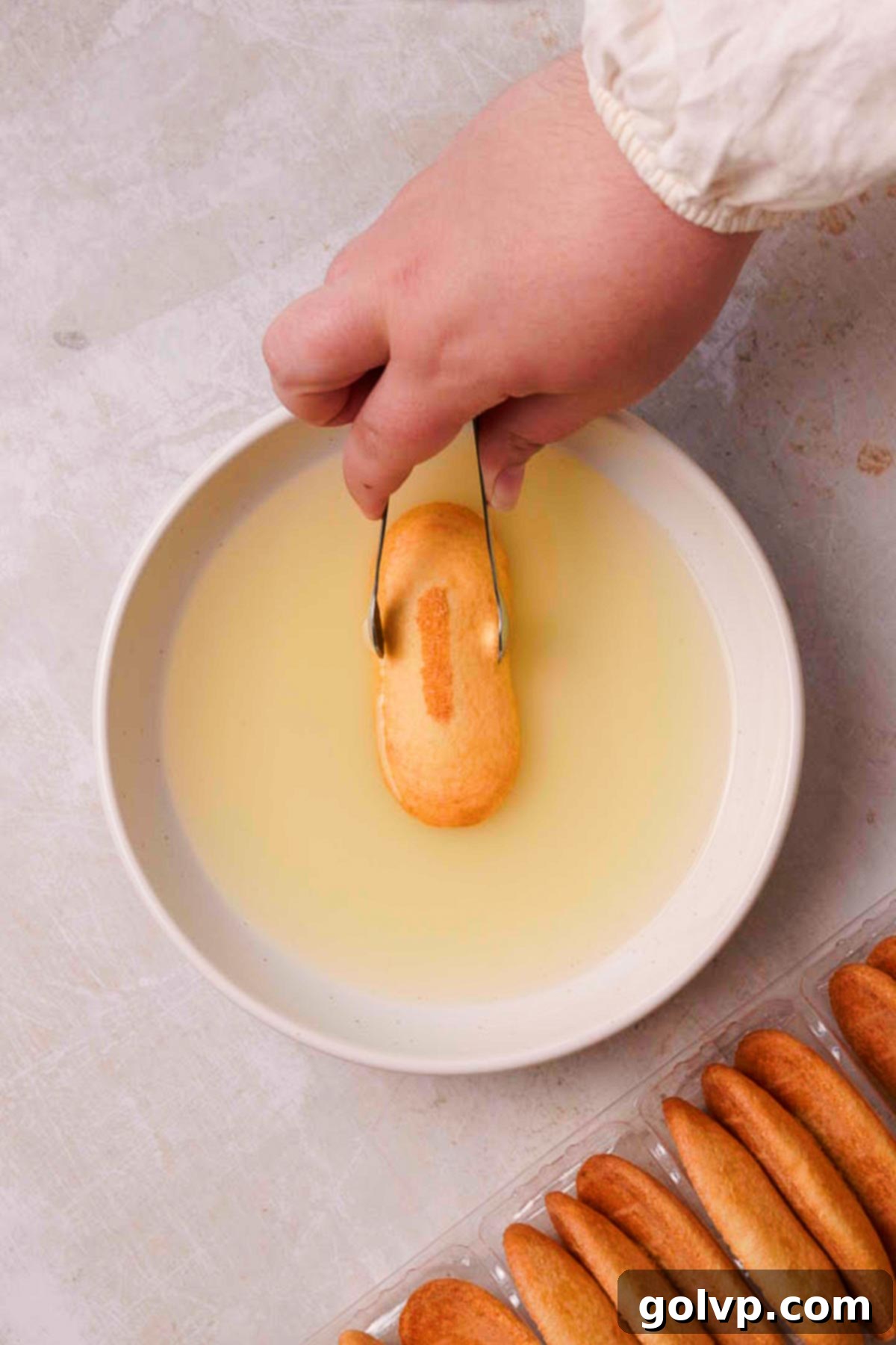 dip ladyfingers into lemon syrup with tongs
