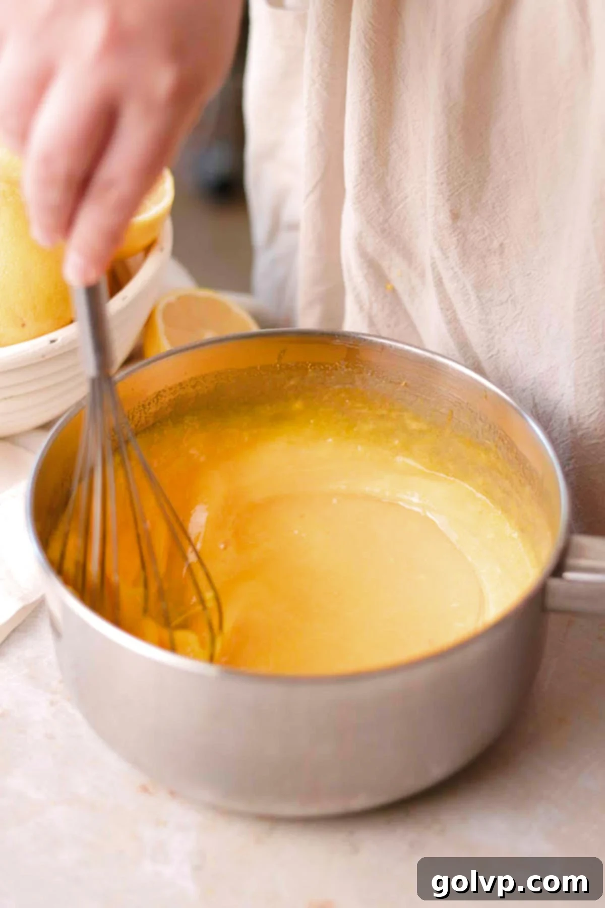 stirring uncooked lemon curd in saucepan with silicone spatula