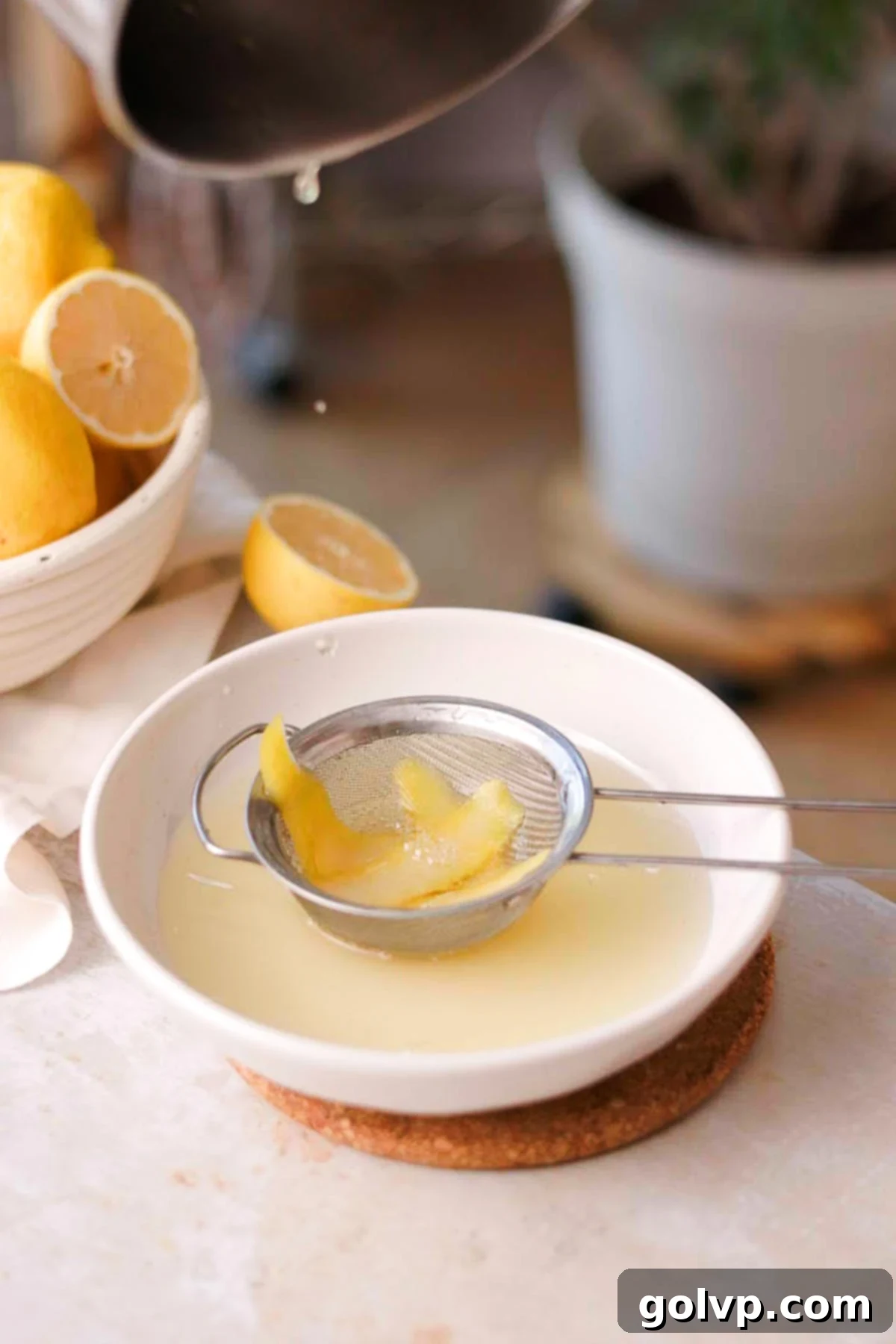 straining lemon syrup into a wide bowl