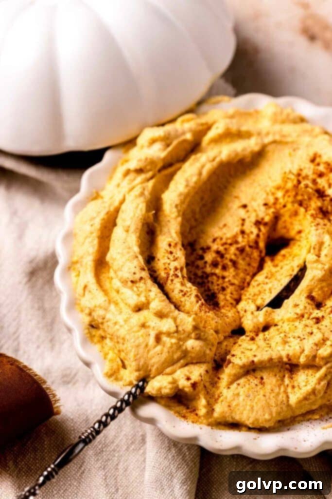 pumpkin whipped cream in a glass pie plate with a spoon