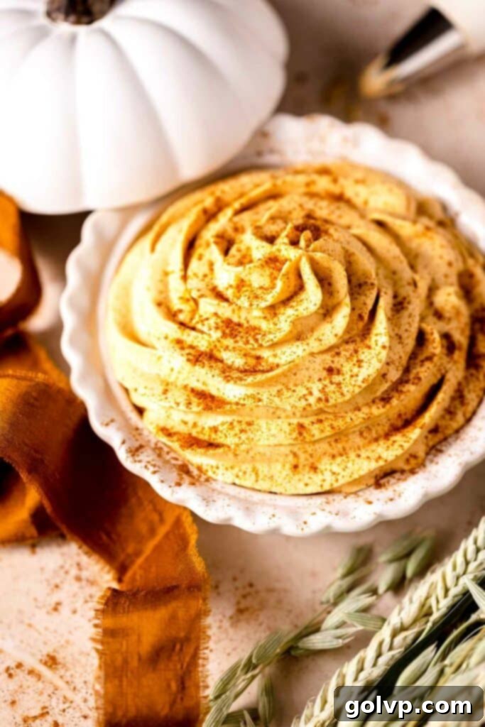 piped orange pumpkin whipped cream in a pie plate with a pumpkin lid