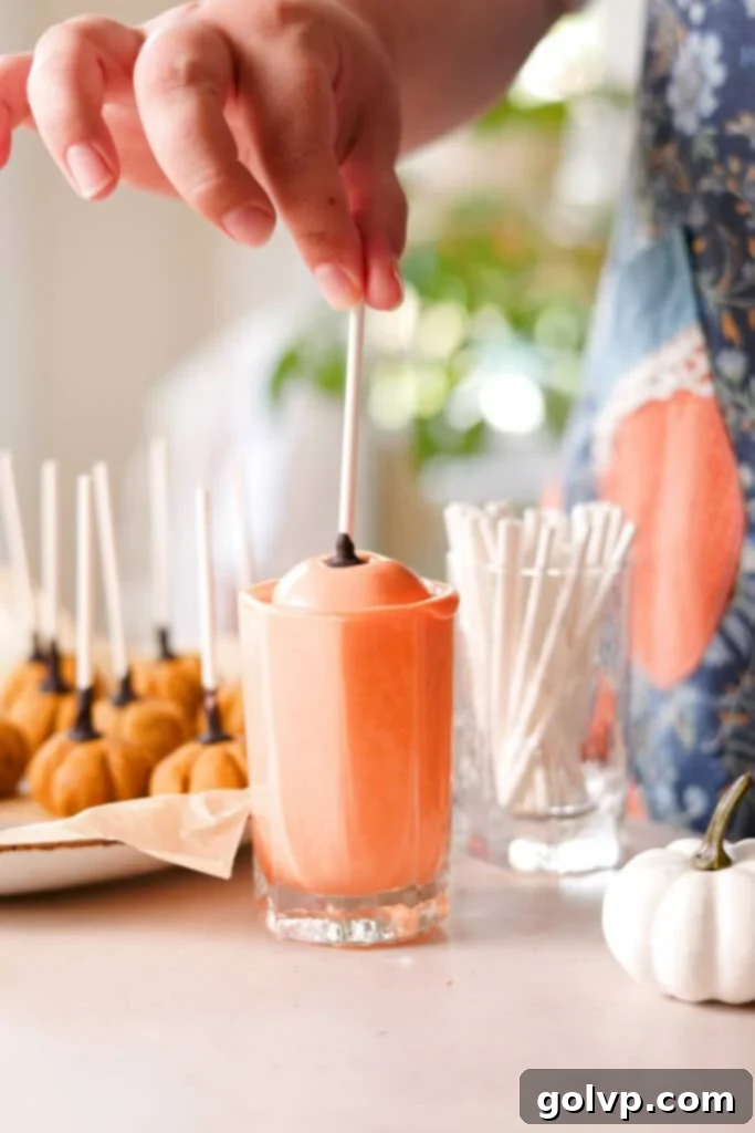 dipping cake pops in orange melted candy melts