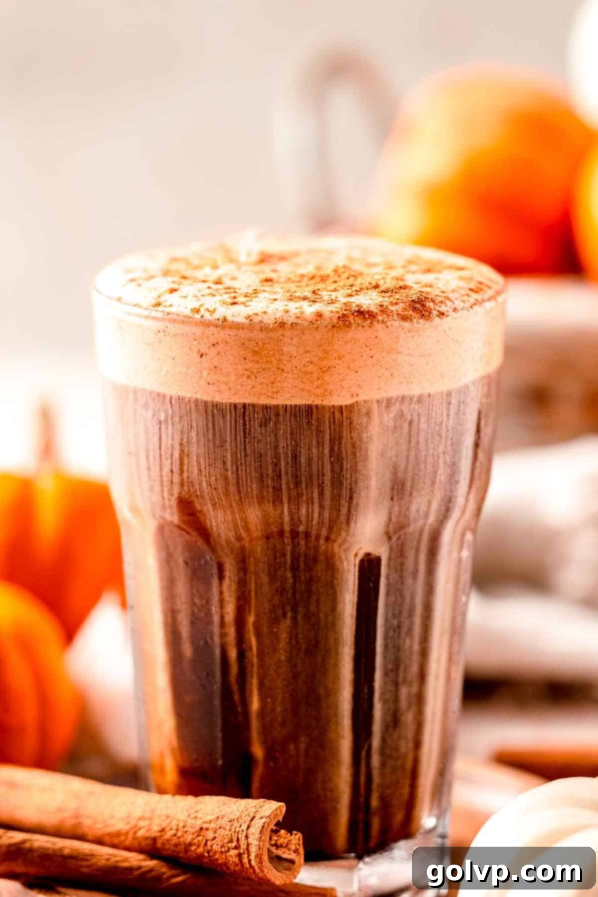 A glass filled with dark cold coffee, beautifully topped with a generous swirl of creamy pumpkin cold foam, creating an inviting and delicious fall beverage.