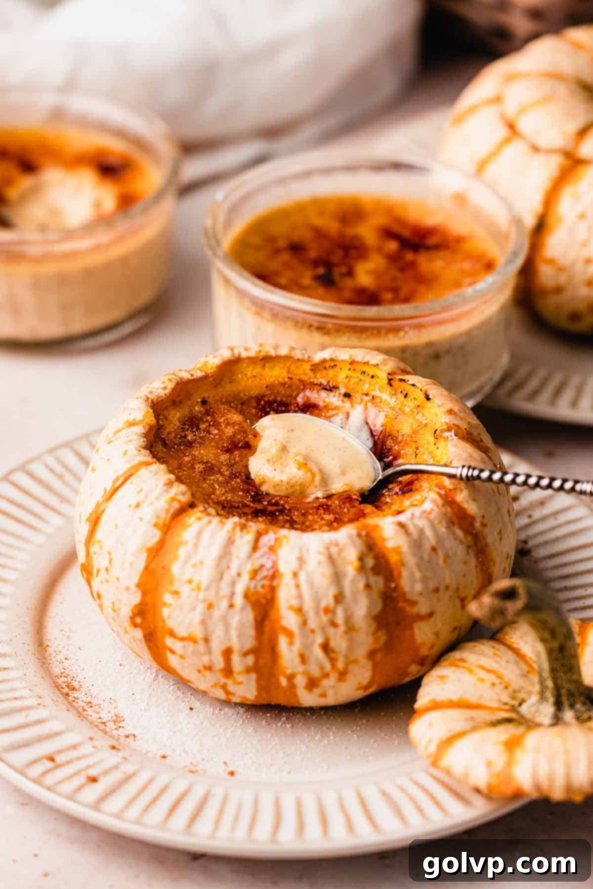creme brulee inside of a pumpkin with spoon