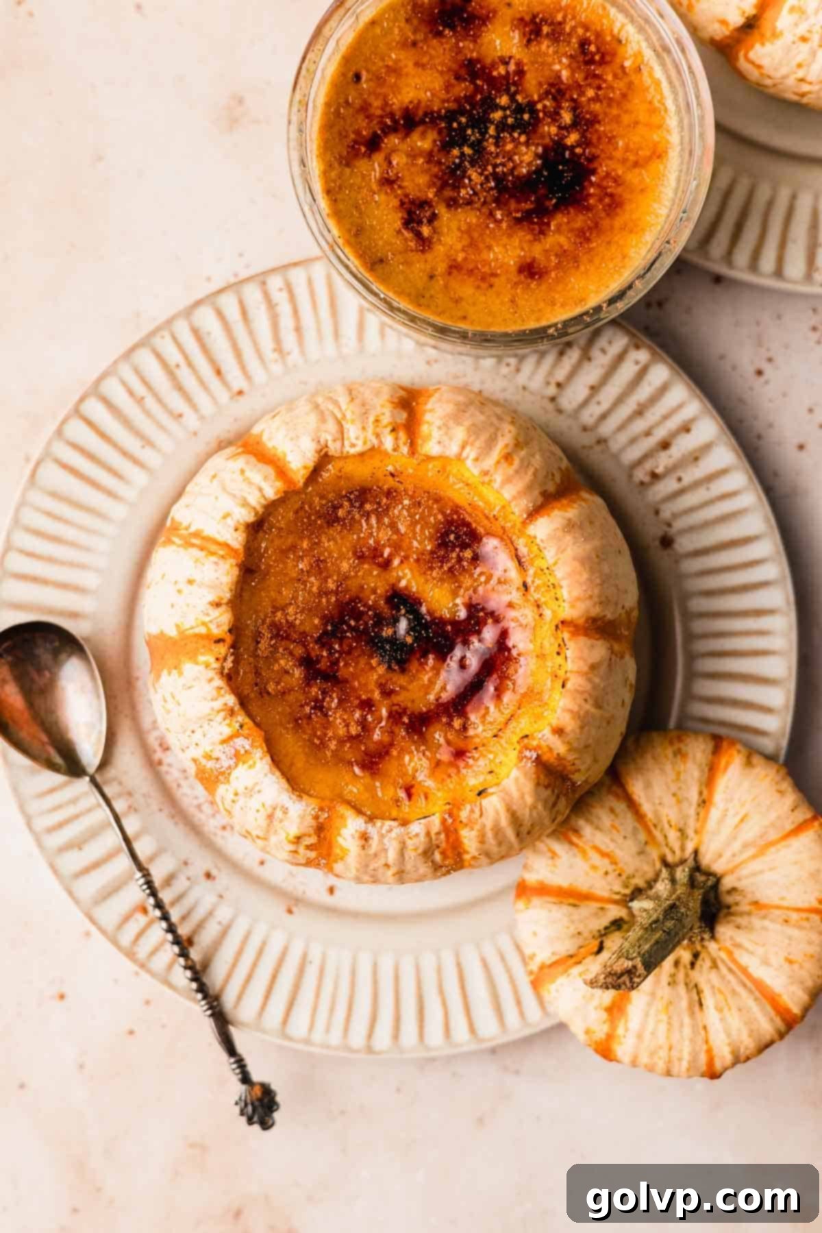 creme brulee with burnt sugar top inside pumpkin on top of a ribbed plate