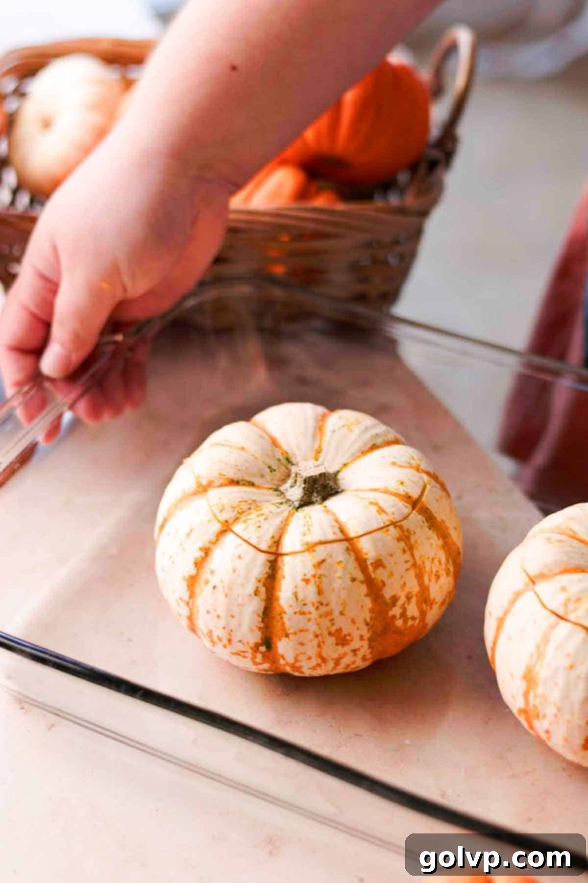 mini pumpkins with tops cut off on glass baking dish