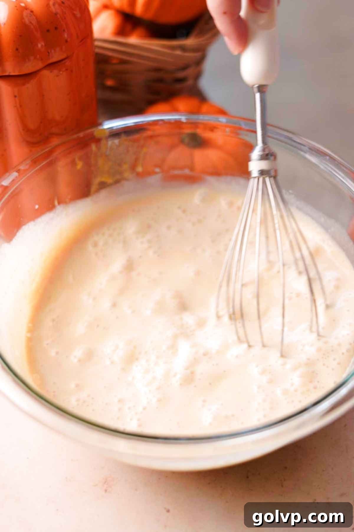 whisking cream and milk into creme brulee