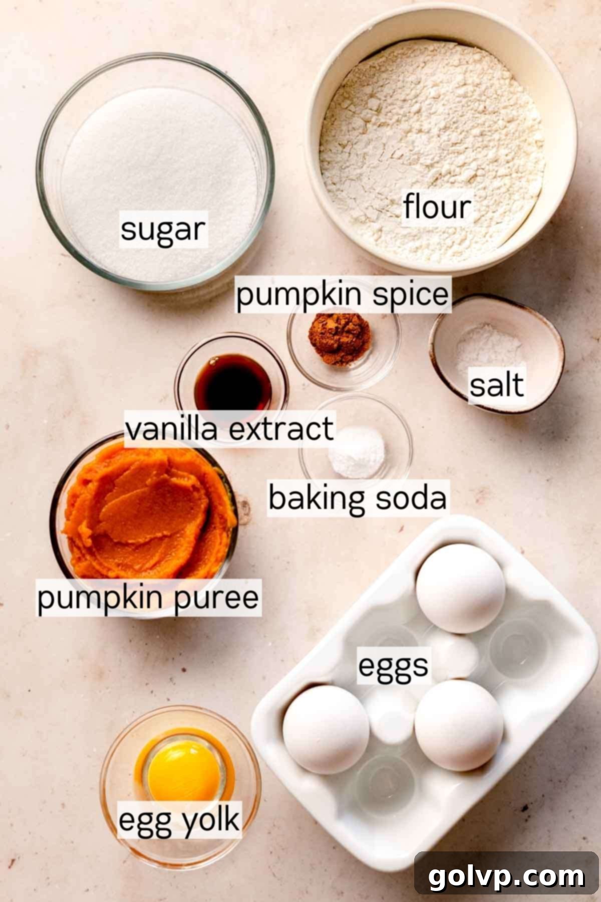 Essential ingredients for the pumpkin roll cake, including pumpkin puree, spices, and flour, laid out on a kitchen surface.