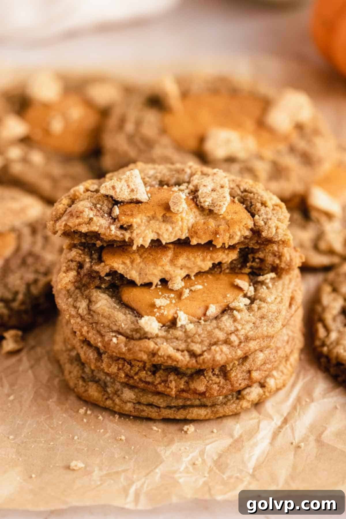 stack of pumpkin cheesecake cookies on parchment paper